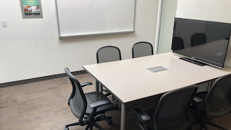 table, 2 chairs, whiteboard, and projector screen