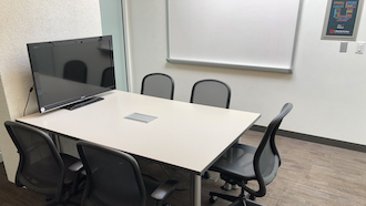 table, 2 chairs, whiteboard, and projector screen