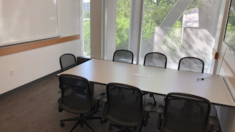 table, 2 chairs, whiteboard, and display monitor