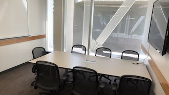 table, 2 chairs, whiteboard, and display monitor