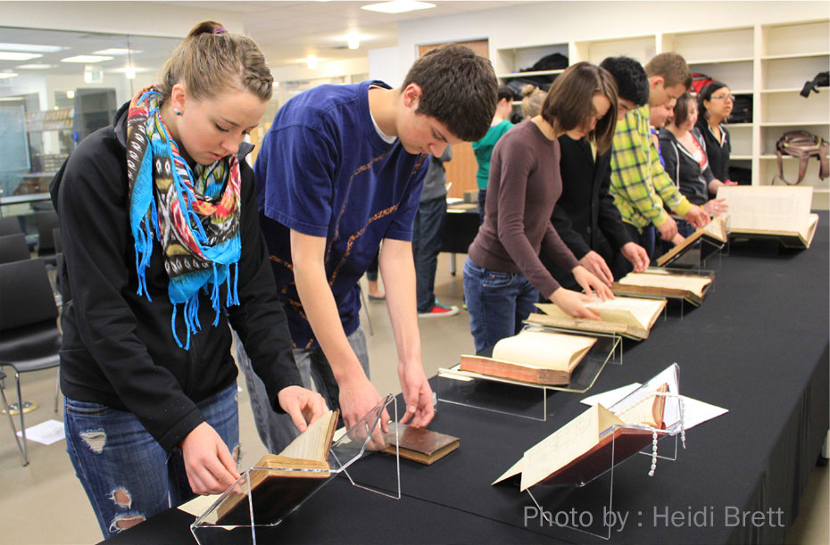 Students from Professor Ann Engar's Honors ITW course, Spring Semester 2011. Students carefully examine rare books on display in a library or archive. Photo by Heidi Brett.