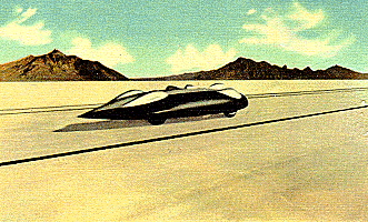 A vintage car drives through a vast desert landscape under a clear blue sky