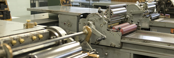Close-up of vintage printing presses with rollers and metal components in a studio setting