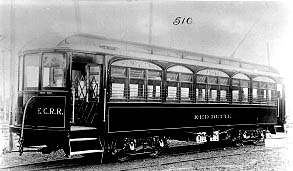 Historic black and white photo of an elegant E.C.R.R. train car with multiple arched windows and detailed trim.